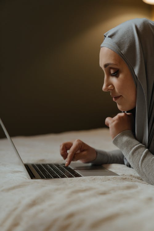 Woman in Gray Hijab Using Macbook Pro