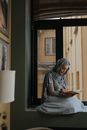 Woman in Gray Hijab Reading Book