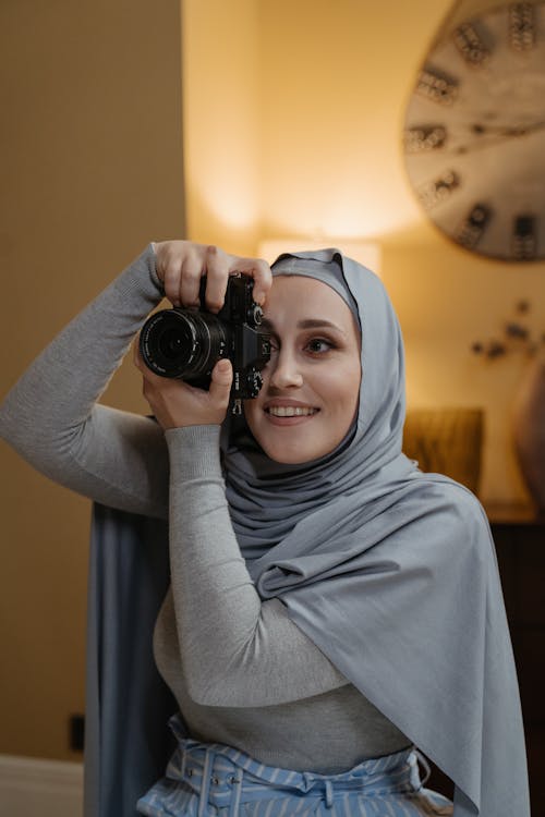 Woman in Gray Hijab Holding Black Dslr Camera