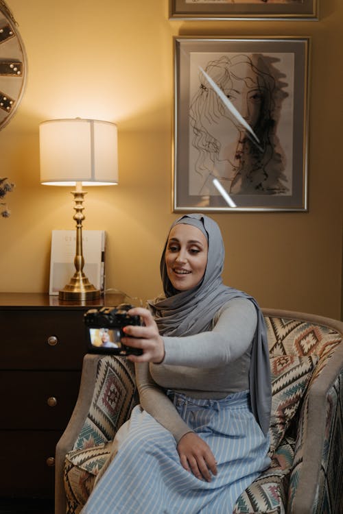 Woman in Gray Hijab Sitting on Sofa Chair