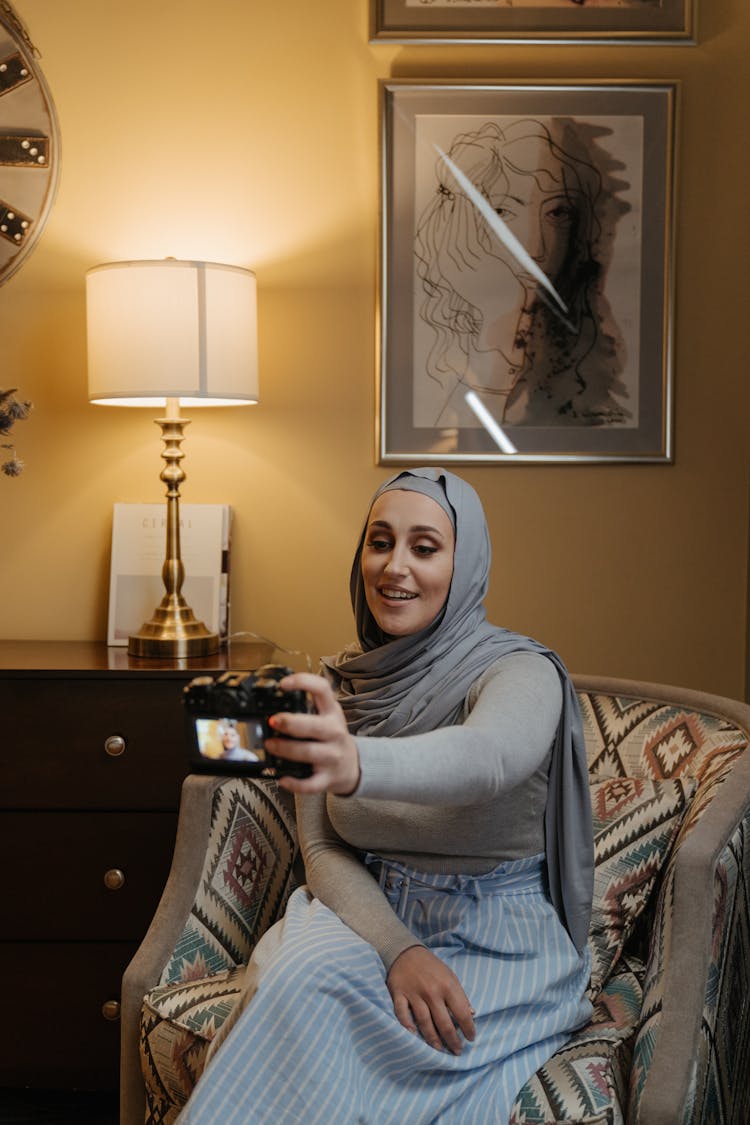 Woman In Gray Hijab Sitting On Sofa Chair