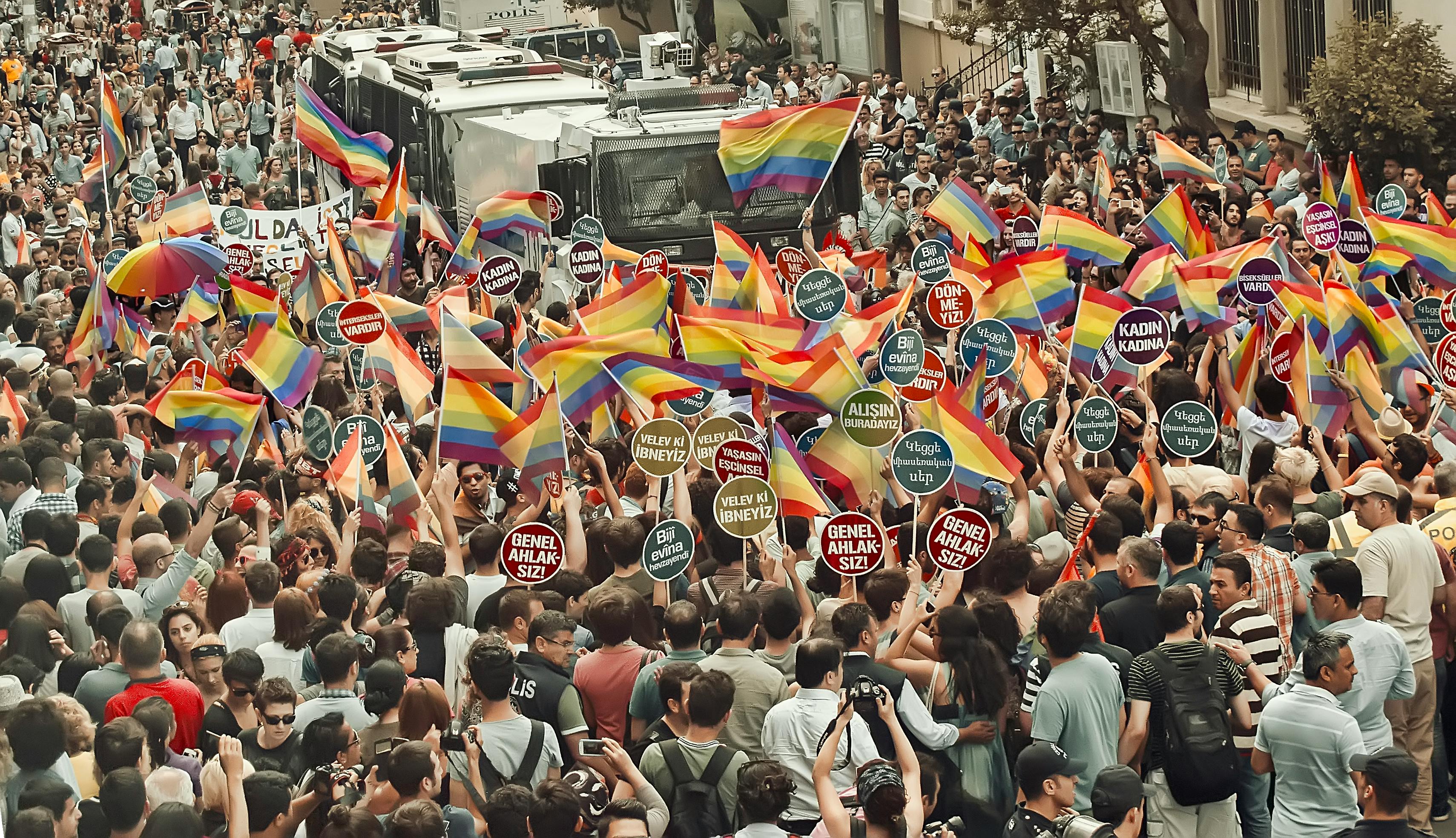 unrecognizable people with rainbow flags during gay pride