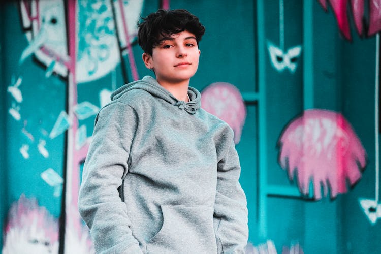 Stylish Teen In Hoodie Near Colorful Wall