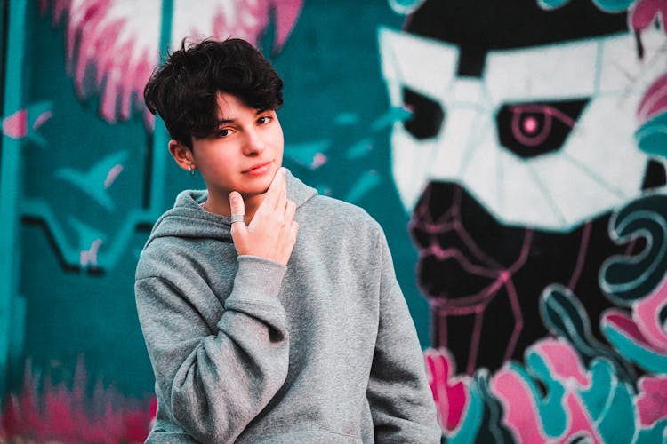 Stylish Male Teen In Hoodie Near Graffiti Wall