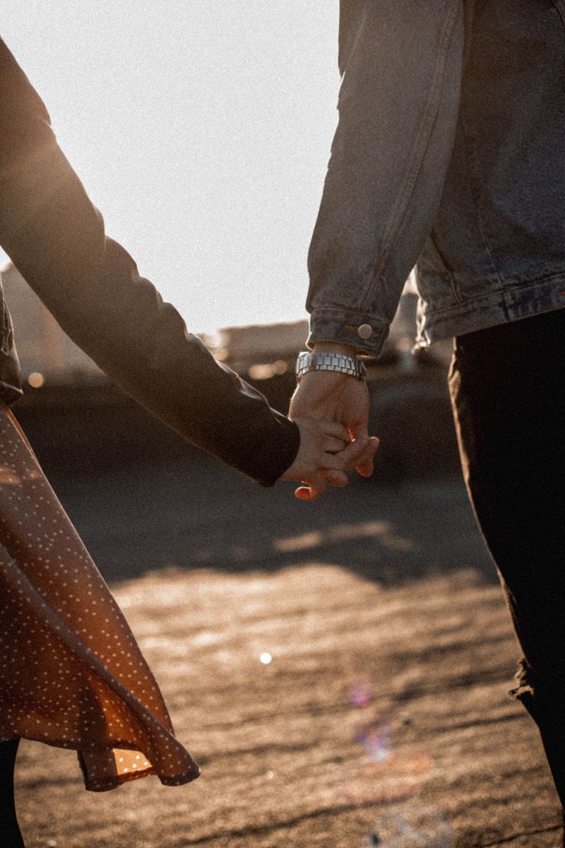 Close-up of a couple holding hands during golden hour