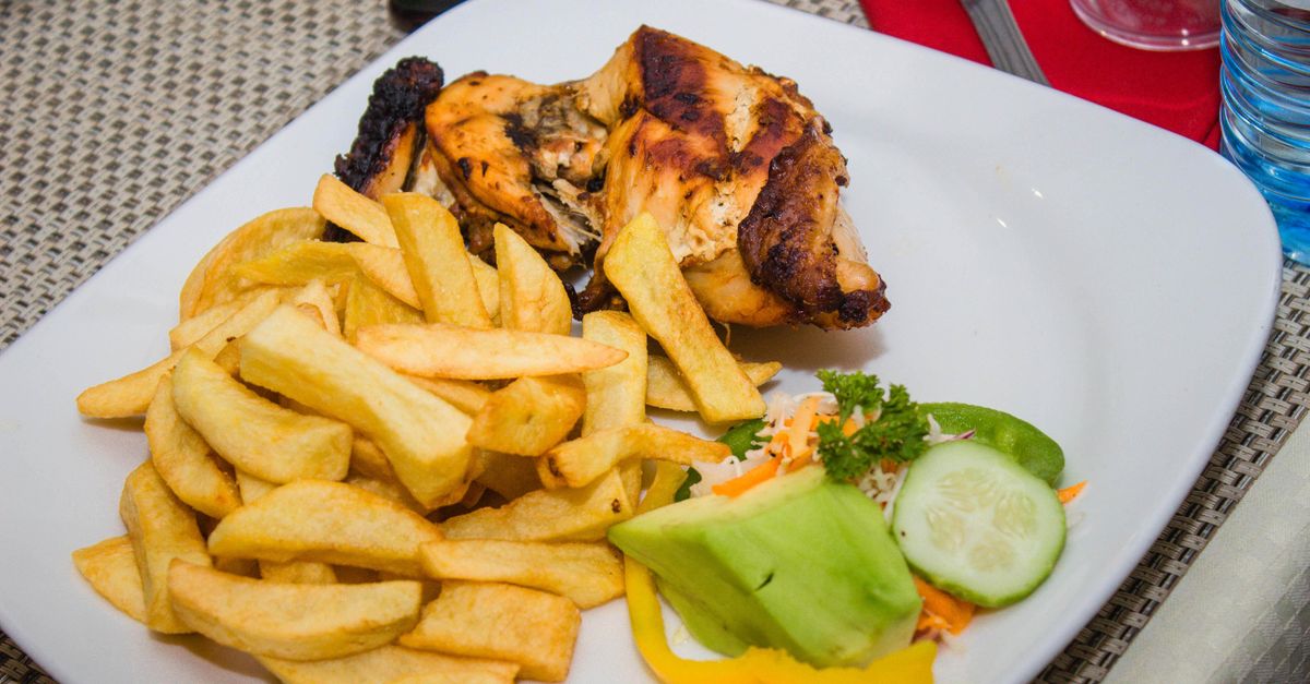 Close-up of a plate of grilled tilapia and banku at Christ Embassy Loveworld Arena food court, with steam rising