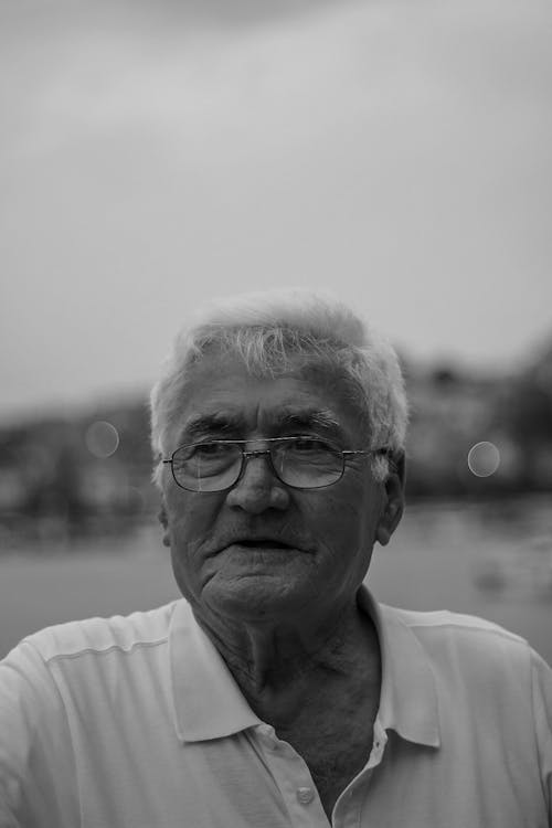 Elderly Man in Collared Shirt Wearing Eyeglasses While Looking Afar