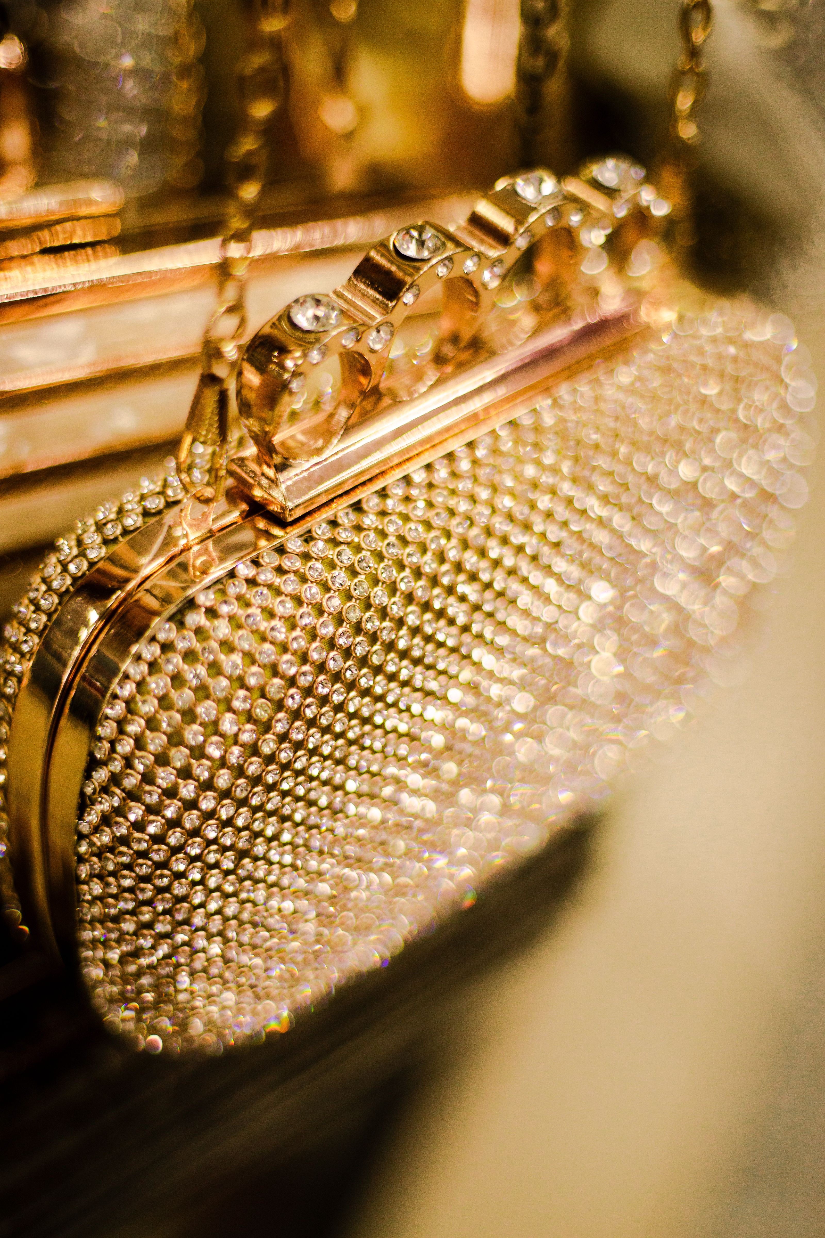 Um close impressionante de uma luxuosa bolsa de mão dourada cravejada de diamantes, exibindo elegância e opulência.