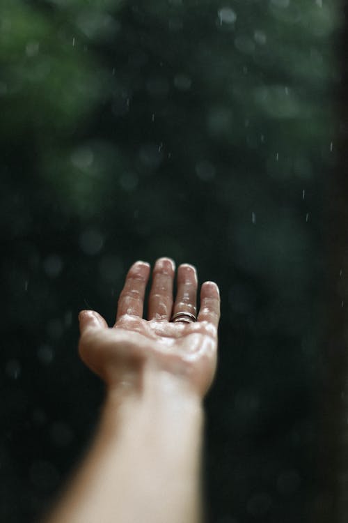 A Hand Feeling the Raindrops 