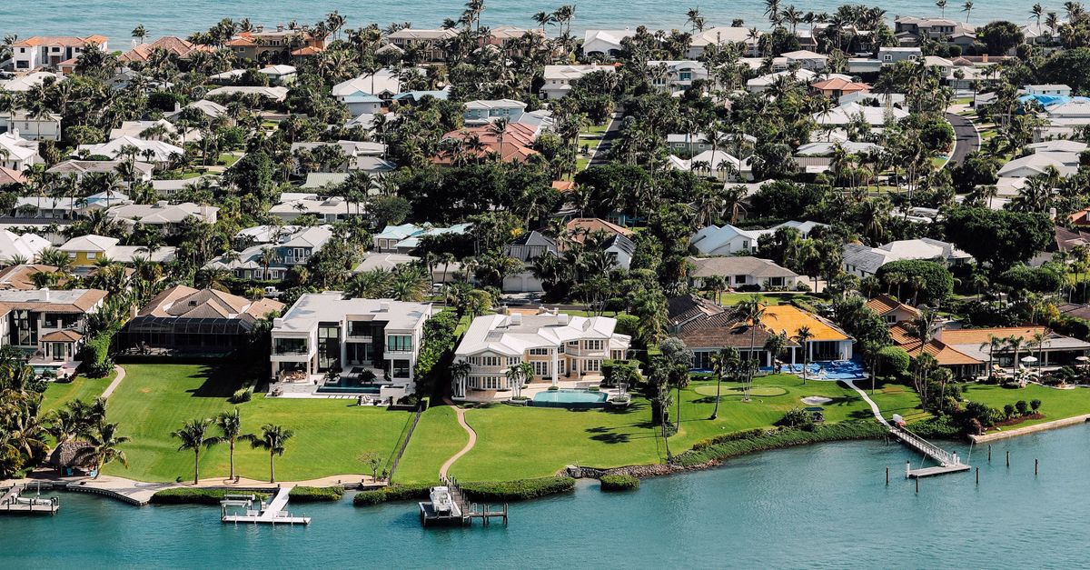 Aerial view of luxurious waterfront mansions on a tropical island.