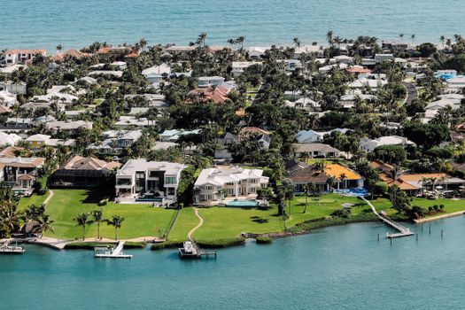 Aerial view of luxurious waterfront mansions on a tropical island.