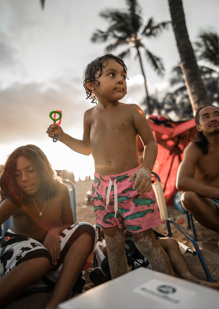 Hispanic Boy With Natives On Sandy Tropical Beach