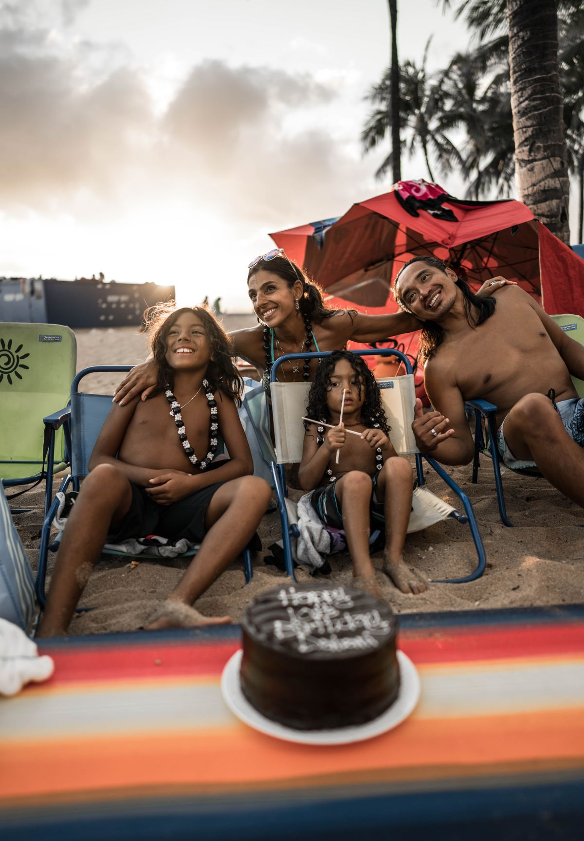 A smiling family embracing during a celebration on a tropical beach