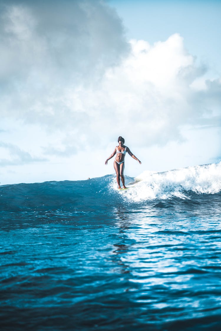 Fit Woman Standing On Surfboard On Sea Wave