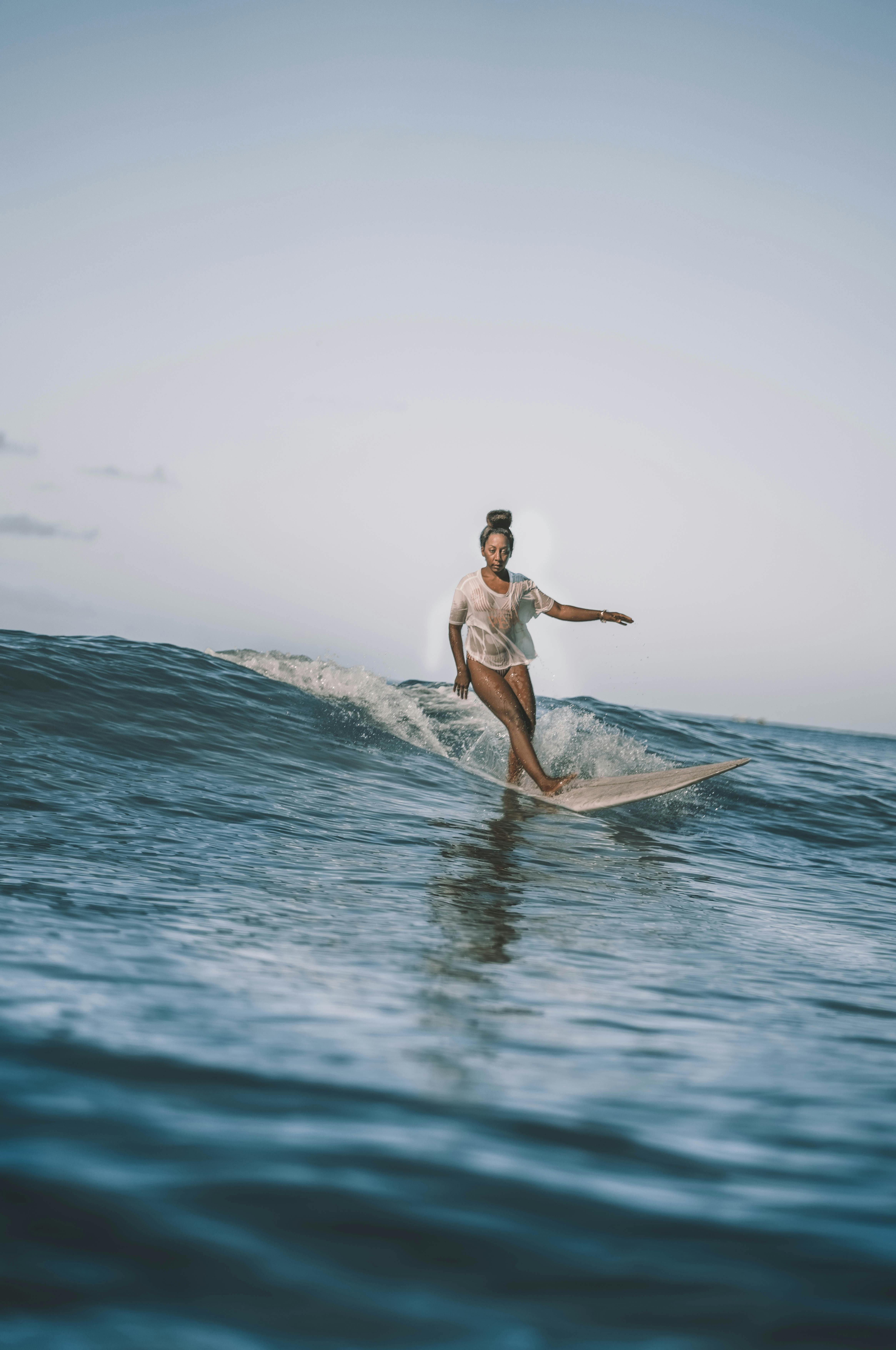 Focused male surfer lying on surfboard on seawater · Free Stock Photo