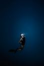 Unrecognizable woman diving in blue sea water