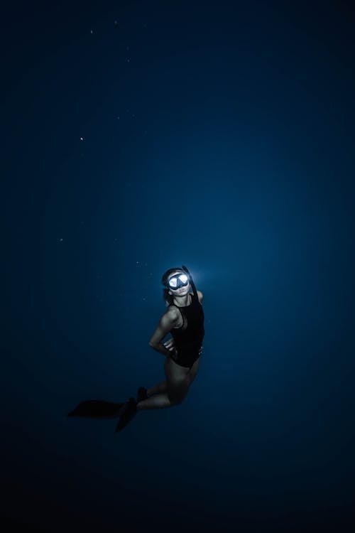 Free Unrecognizable woman diving in blue sea water Stock Photo