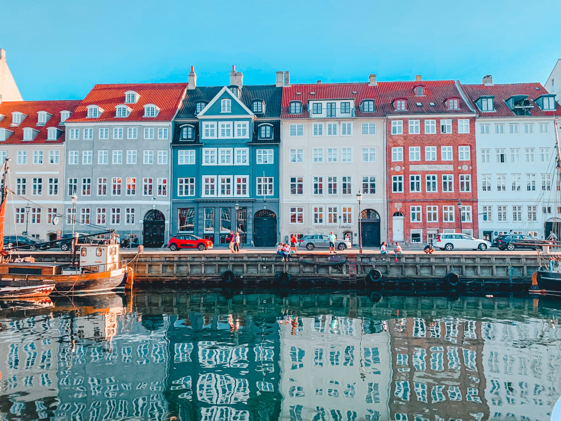 Colorful buildings along a peaceful canal in Copenhagen, Denmark captured in daylight.