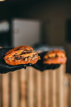 Savor the deliciousness of gourmet burgers with a close-up view of cheese and meat held with gloves, perfect for food lovers.