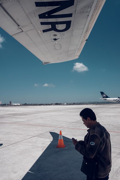 Ethnic man standing near aircraft on sunny day
