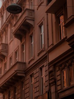 Low angle of balconies and windows of modern building located on city street at sunset