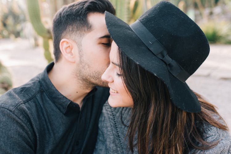 Close-up Of A Man Kissing A Woman In The Cheek