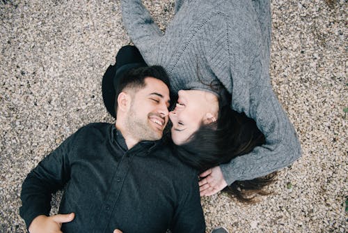 Free Woman in Gray Sweater Lying on the Ground with a Man Stock Photo