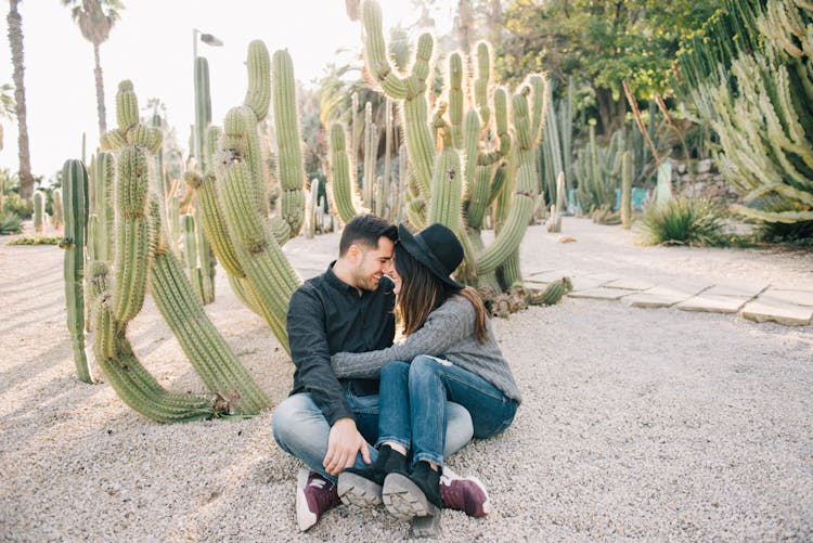 Couple Sitting On The Ground While Looking At Each Other