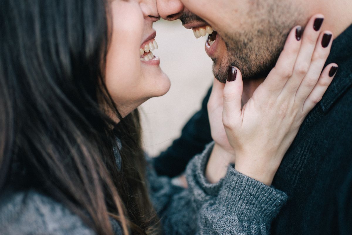 Happy couple laughing face to face after learning how couples stop passing bacteria back and forth