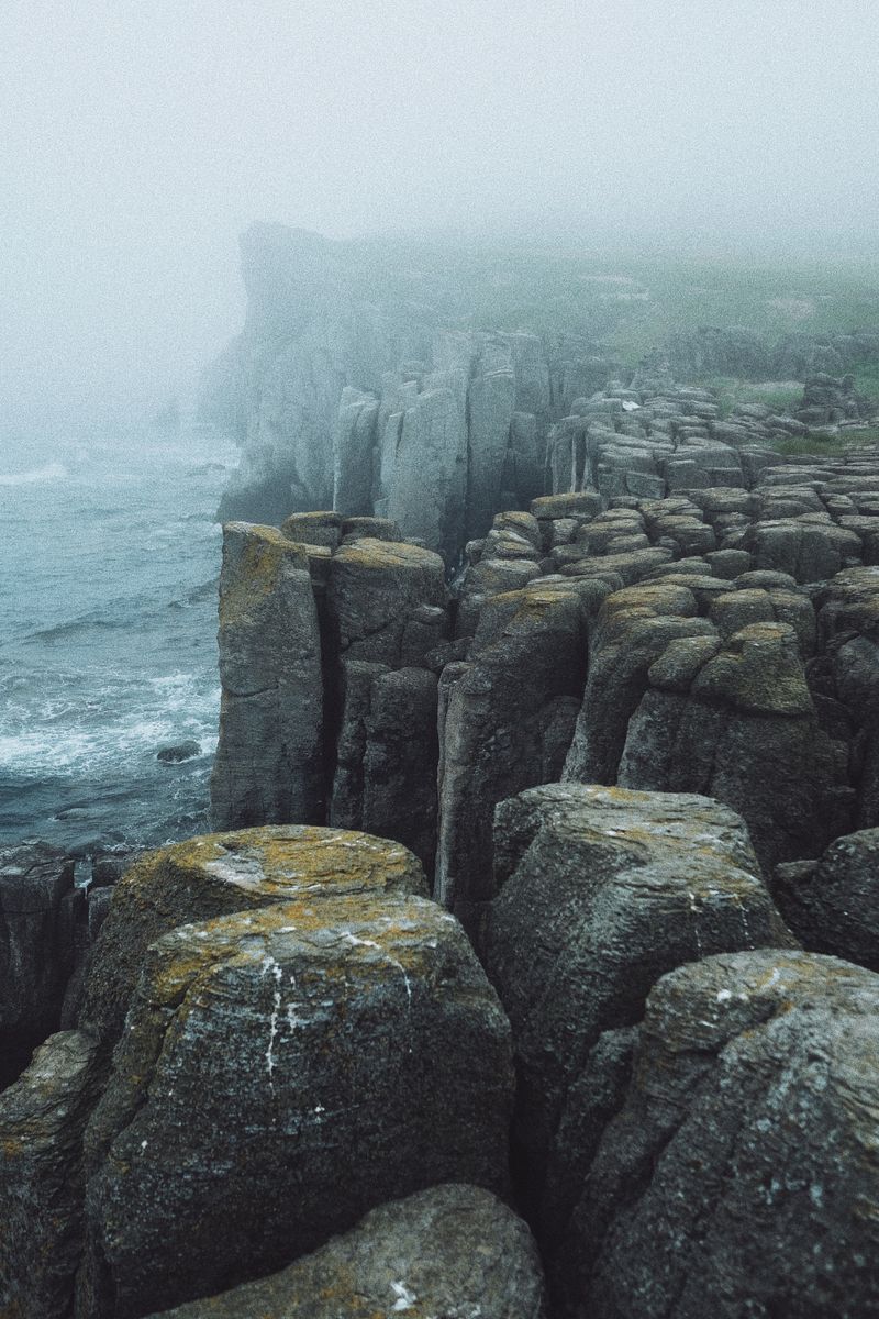 Foggy coastal cliffs with dramatic boulders by the sea, pinned as a mood reference — photo by Nadezhda Moryak on Pexels