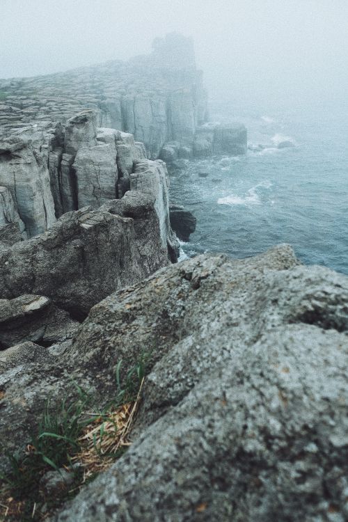Misty cliffside above breaking water, photo by Nadezhda Moryak on Pexels