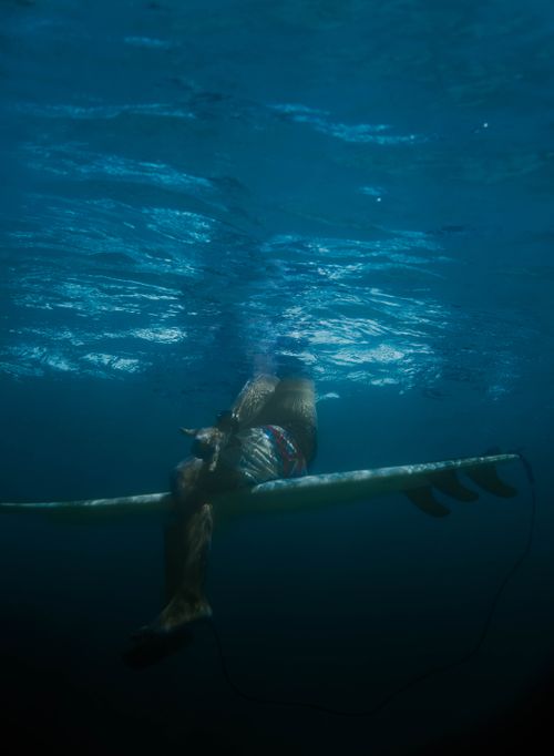 Free Unique underwater shot capturing a surfer resting on a surfboard, ready for the next wave. Stock Photo