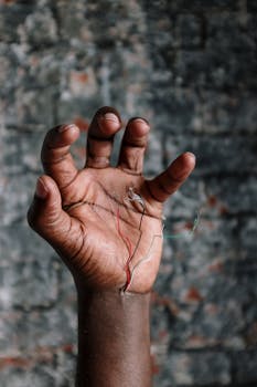 Close-up of a human hand with exposed wires, exploring futuristic technology themes.