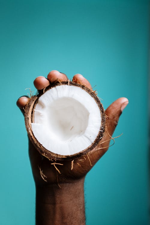 Photo Of Person Holding Sliced Coconut