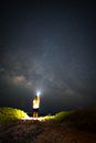 夜空下，一个人站在宁静的户外，被星星和银河照亮