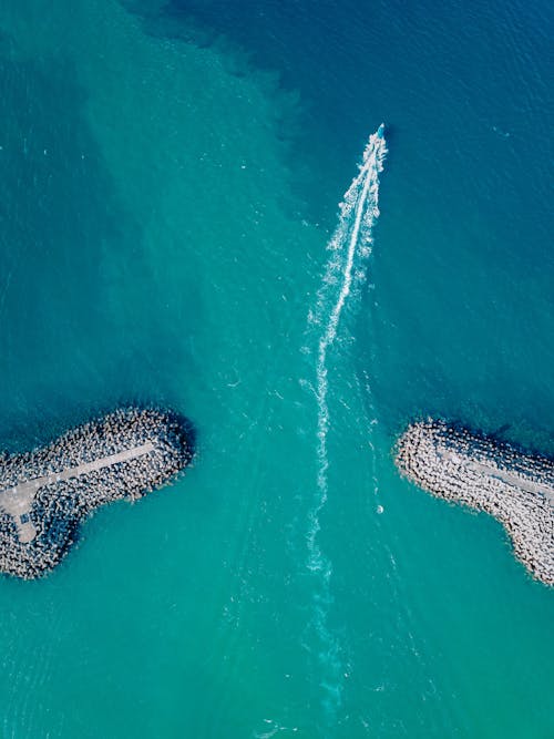 Aerial View of A Boat Crossing Between Breakwaters