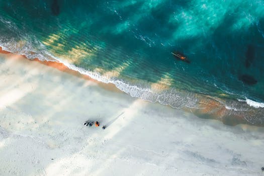 Breathtaking aerial shot of a tranquil beach with turquoise ocean waves crashing onto the shore.