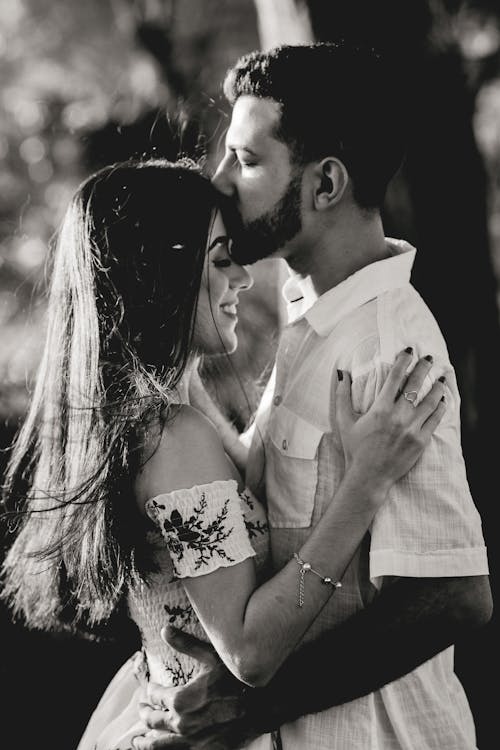 бесплатная Фотография мужчины, целующего женщину в лоб Стоковое фото