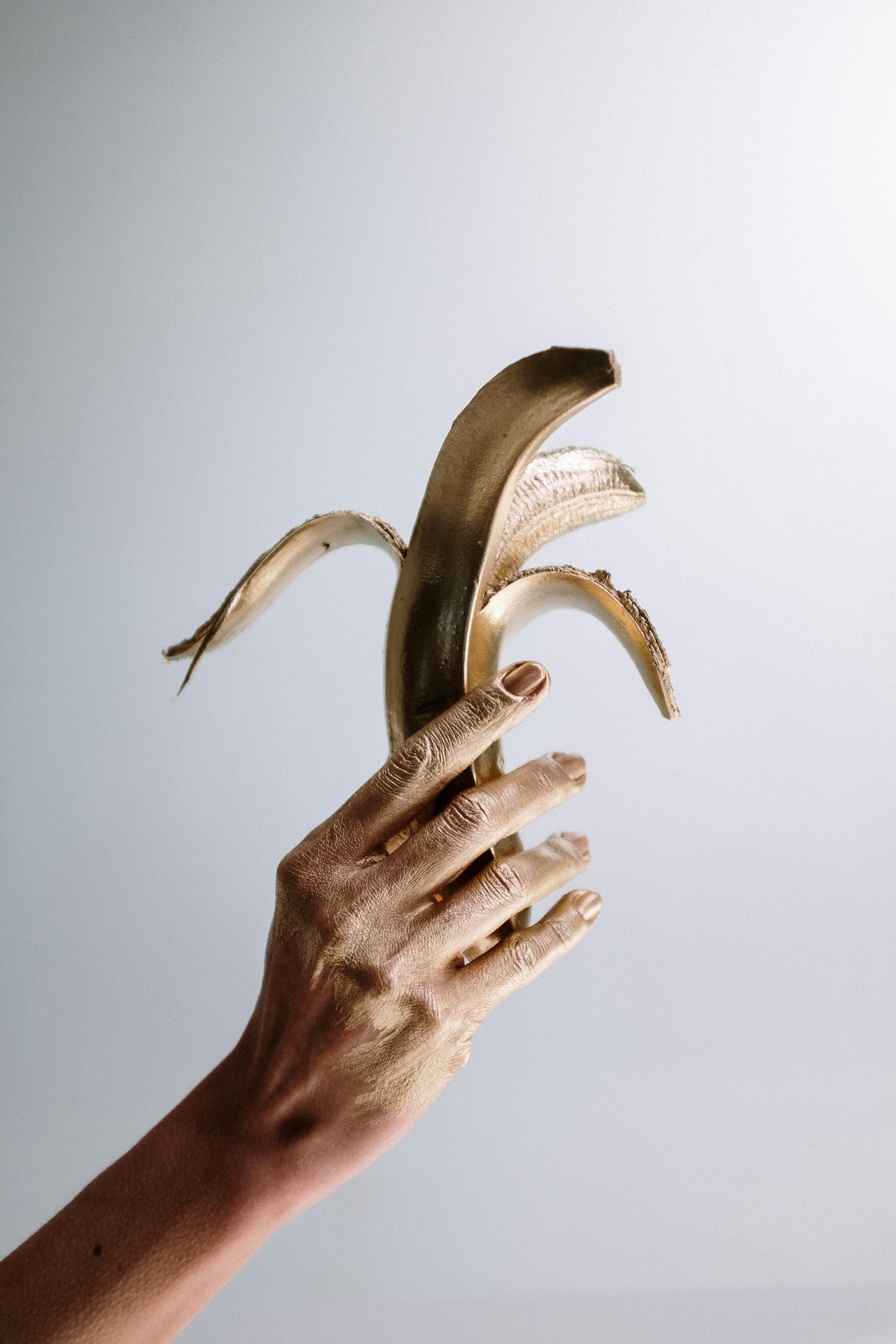 photo of person holding golden banana