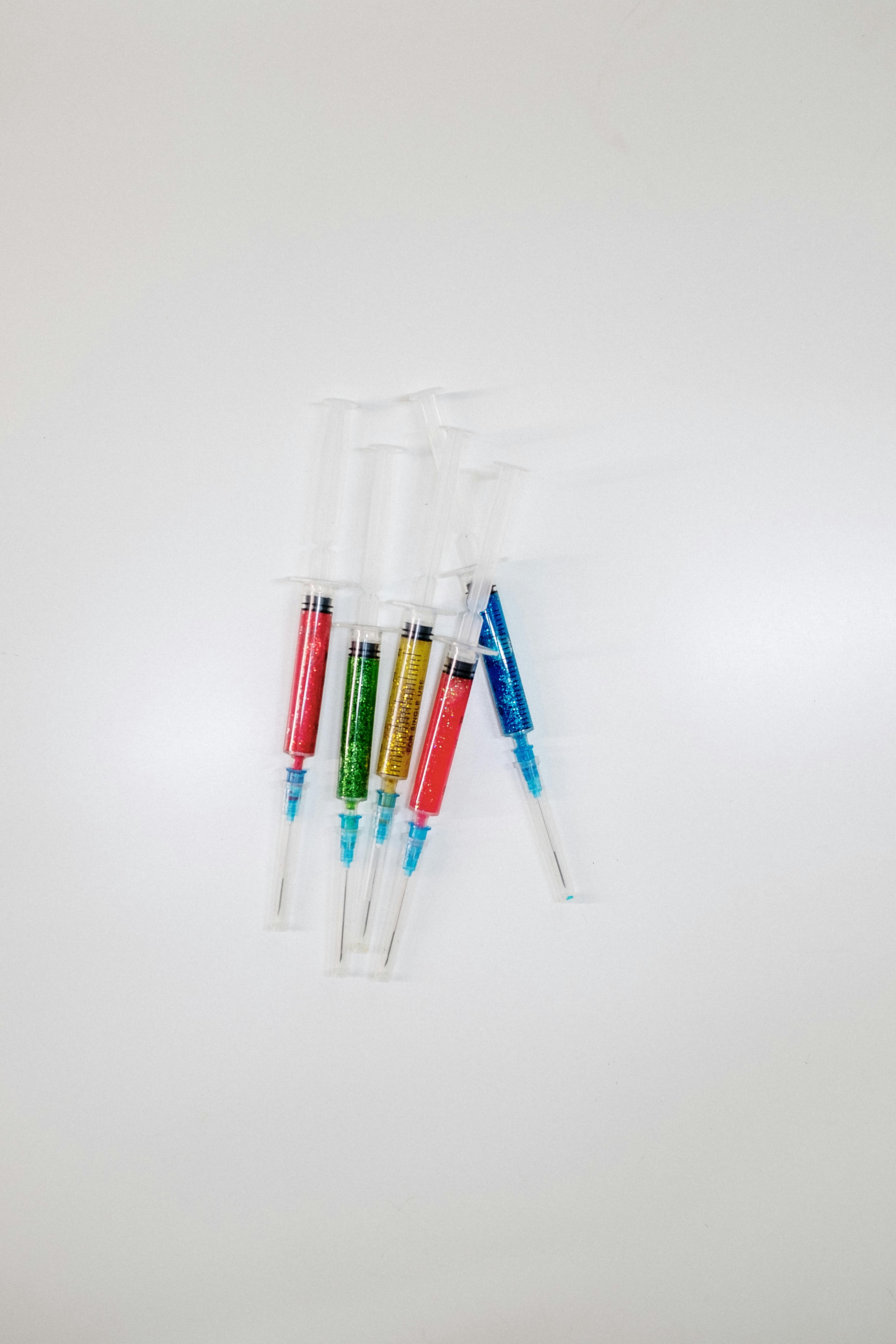 一套充满活力、闪闪发光的注射器整齐地排列在纯白表面上