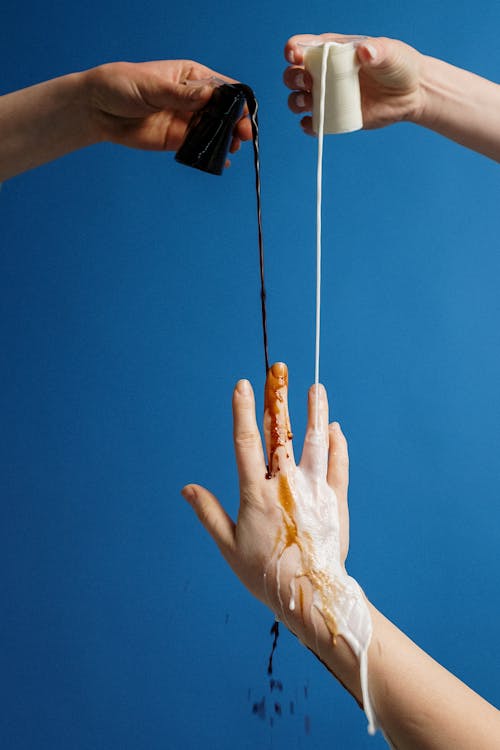 Photo Of People Pouring Black And White Liquid