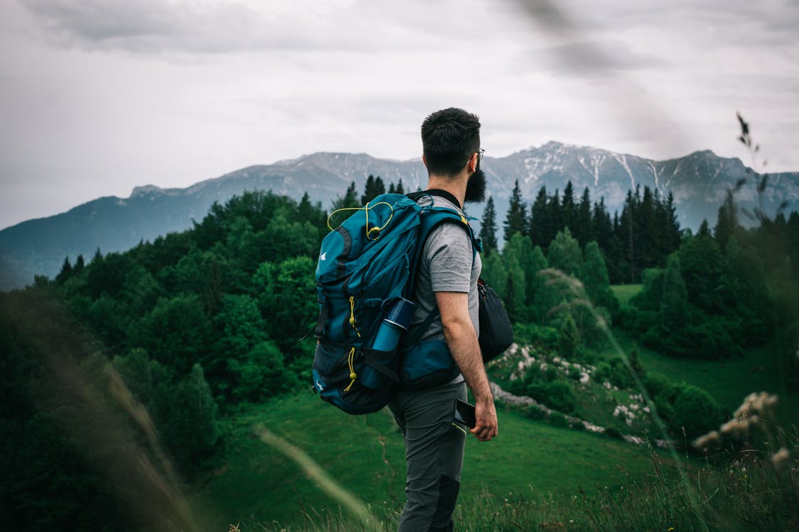 A Man Carrying His Backpack Overlooking the Landscape Scenery