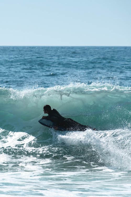 A Person Surfing on the Big Waves of the Sea