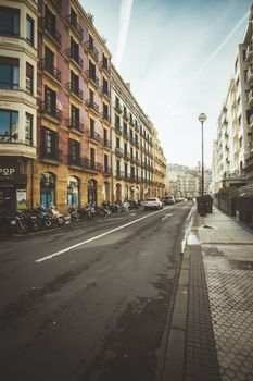 A vibrant urban street in Donostia-San Sebastian, Spain showcasing classic European architecture.