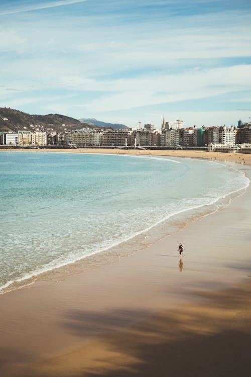 Photo Of Person Walking Beside Beach