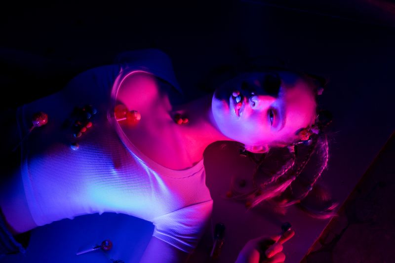 Conceptual portrait of a woman with braided hair in neon light