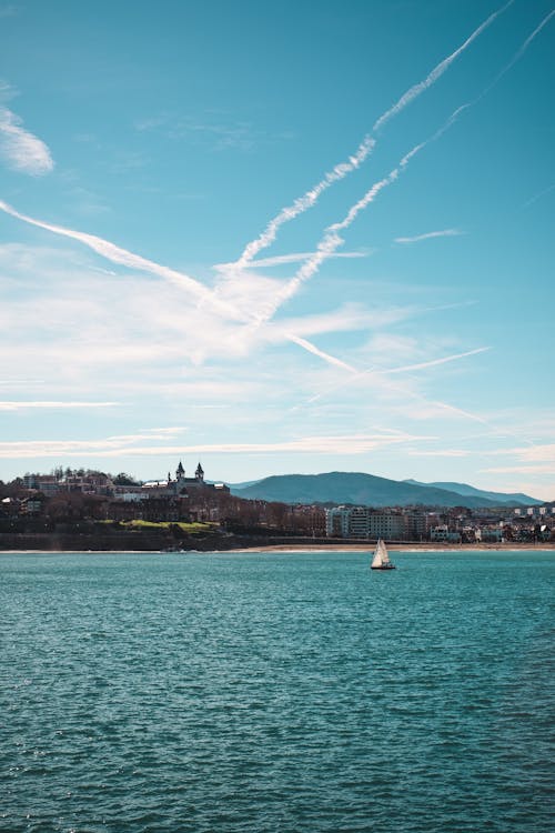 White Sailing Boat on Sea Under Blue Sky