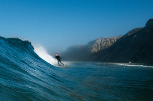 Free Person Surfing on the Big Waves of a Sea Stock Photo