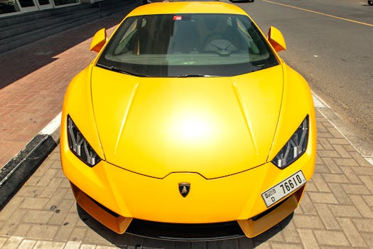 Front view of a parked yellow Lamborghini Aventador on a sunny Dubai street.