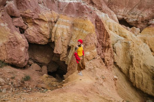 Woman standing in a vibrant rocky canyon, exploring natural rock formations.